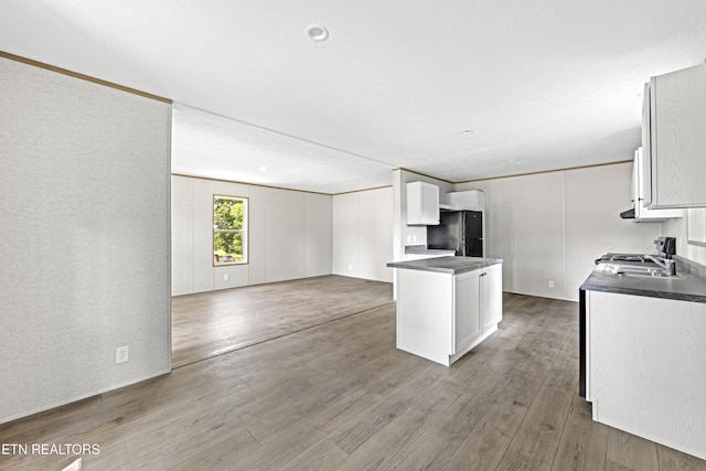 417 Cain Ave, Morristown, TN 37813 - kitchen featuring freestanding refrigerator, dark countertops, open floor plan, wood finished floors, and white cabinetry