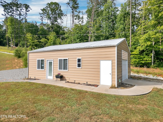 5728 Hickory Valley Rd, Heiskell, TN 37754 - back of house featuring an outbuilding, a metal roof, a lawn, and a garage