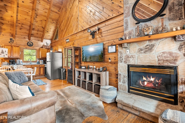 524 Hoot Owl Way, Gatlinburg, TN 37738 - living room featuring light wood finished floors, wooden walls, high vaulted ceiling, a wood ceiling with exposed beams, and a fireplace