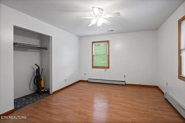 261 Lance Ln, Lafollette, TN 37766 - unfurnished bedroom featuring baseboard heating, light wood-style floors, a closet, and ceiling fan