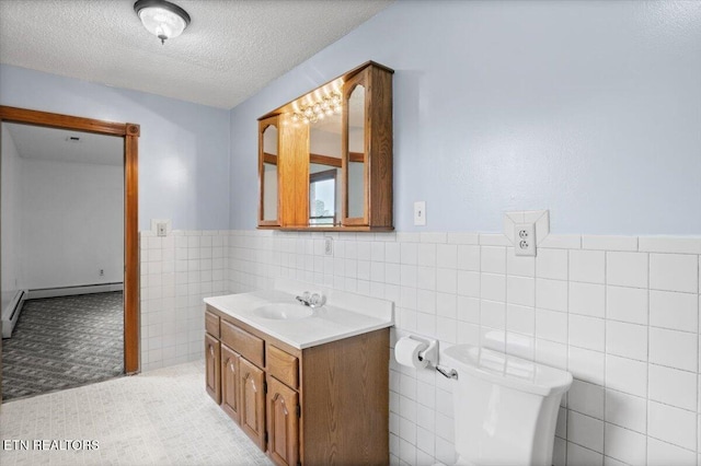 261 Lance Ln, Lafollette, TN 37766 - bathroom with vanity, tile walls, a textured ceiling, a wainscoted wall, and baseboard heating