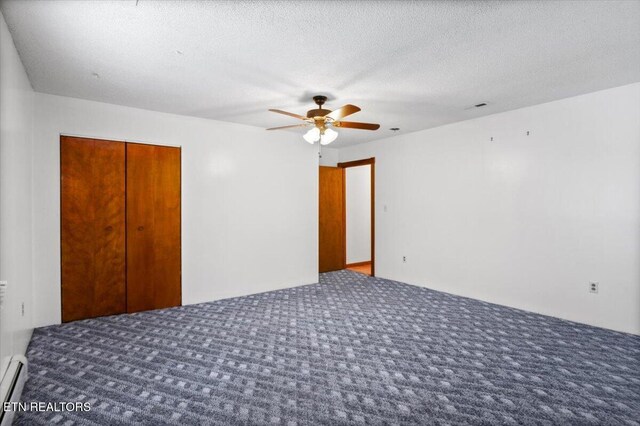 261 Lance Ln, Lafollette, TN 37766 - unfurnished bedroom with carpet flooring, a closet, a baseboard heating unit, a ceiling fan, and a textured ceiling