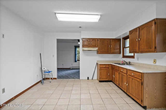 261 Lance Ln, Lafollette, TN 37766 - kitchen with light countertops, brown cabinets, a baseboard heating unit, and under cabinet range hood