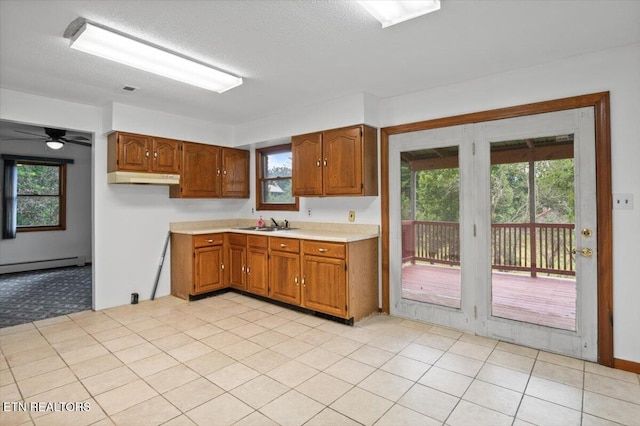 261 Lance Ln, Lafollette, TN 37766 - kitchen featuring light countertops, healthy amount of natural light, brown cabinets, baseboard heating, and a textured ceiling