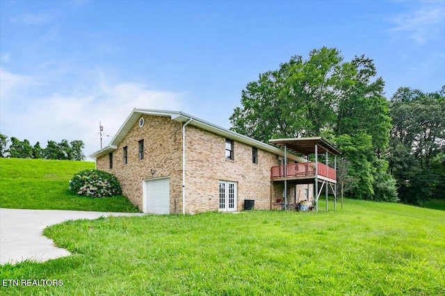 261 Lance Ln, Lafollette, TN 37766 - view of side of property featuring a garage, a yard, a wooden deck, brick siding, and french doors