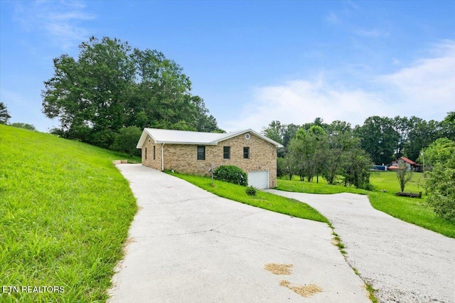 261 Lance Ln, Lafollette, TN 37766 - view of side of property with concrete driveway, a garage, a yard, and brick siding