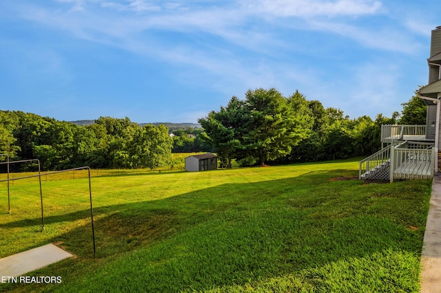3938 Settlers Trl, Kodak, TN 37764 - view of green lawn featuring a storage unit, stairway, and a wooden deck