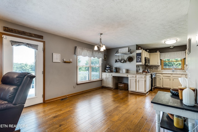 3938 Settlers Trl, Kodak, TN 37764 - kitchen featuring stainless steel appliances, dark wood-style flooring, light countertops, tasteful backsplash, and a textured ceiling