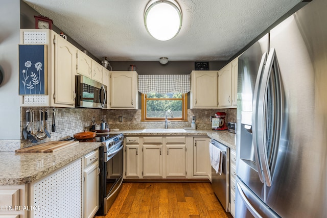 3938 Settlers Trl, Kodak, TN 37764 - kitchen featuring appliances with stainless steel finishes, dark wood finished floors, light countertops, a textured ceiling, and backsplash