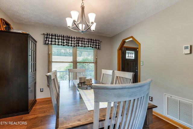 3938 Settlers Trl, Kodak, TN 37764 - dining room with a chandelier, dark wood-style flooring, a textured ceiling, and arched walkways