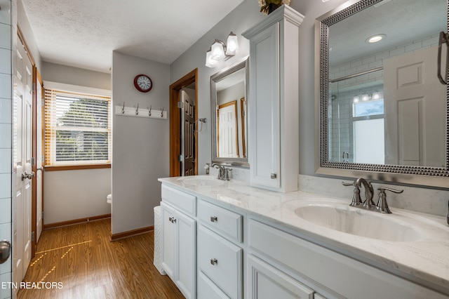 3938 Settlers Trl, Kodak, TN 37764 - bathroom featuring double vanity, wood finished floors, a textured ceiling, and an enclosed shower