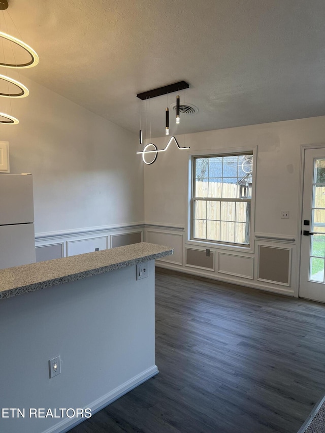 1884 Elmhurst Way, Knoxville, TN 37923 - unfurnished dining area featuring dark wood finished floors, a decorative wall, wainscoting, and a textured ceiling