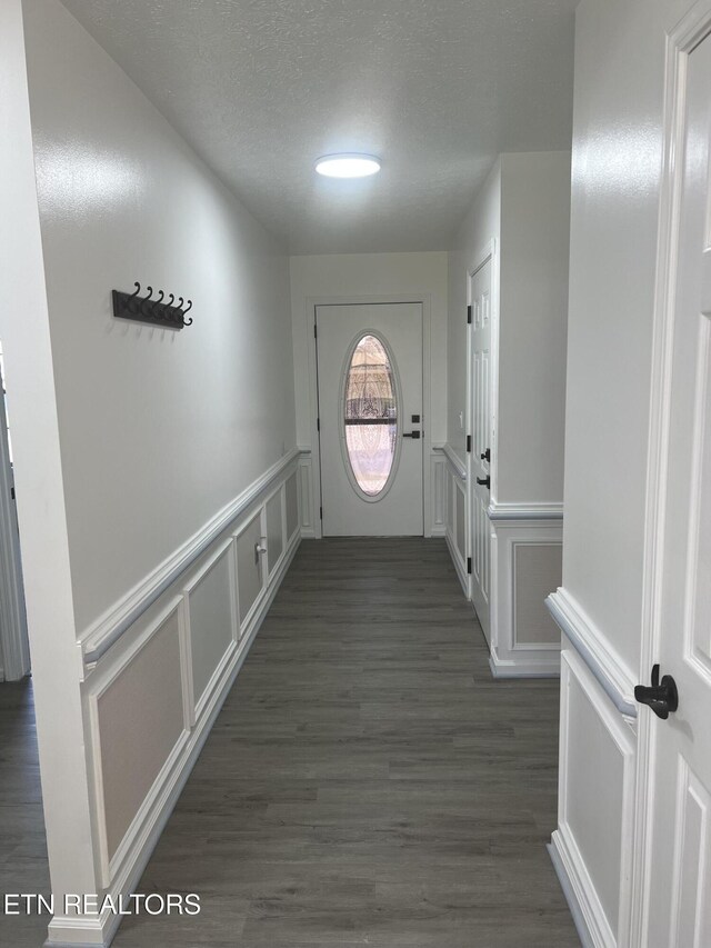1884 Elmhurst Way, Knoxville, TN 37923 - doorway with a decorative wall, a textured ceiling, wainscoting, and dark wood-style floors