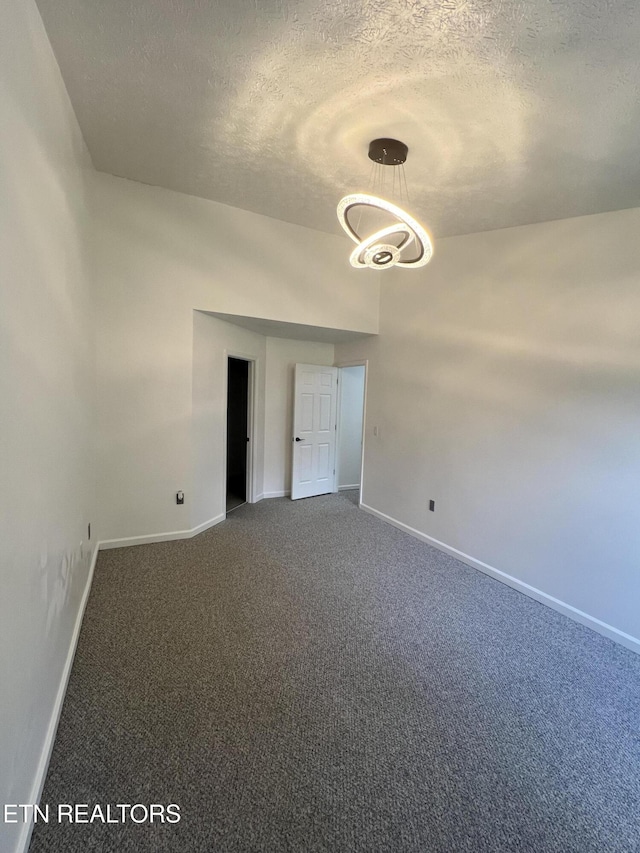 1884 Elmhurst Way, Knoxville, TN 37923 - unfurnished room with a textured ceiling, carpet, and a chandelier