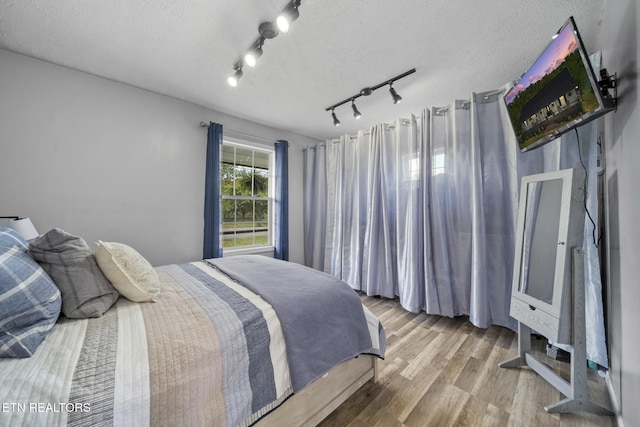 1033 Sunset View Rd, Sevierville, TN 37876 - bedroom featuring wood finished floors, track lighting, and a textured ceiling