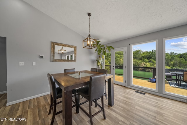 1033 Sunset View Rd, Sevierville, TN 37876 - dining room with light wood-type flooring, a textured ceiling, vaulted ceiling, and a chandelier