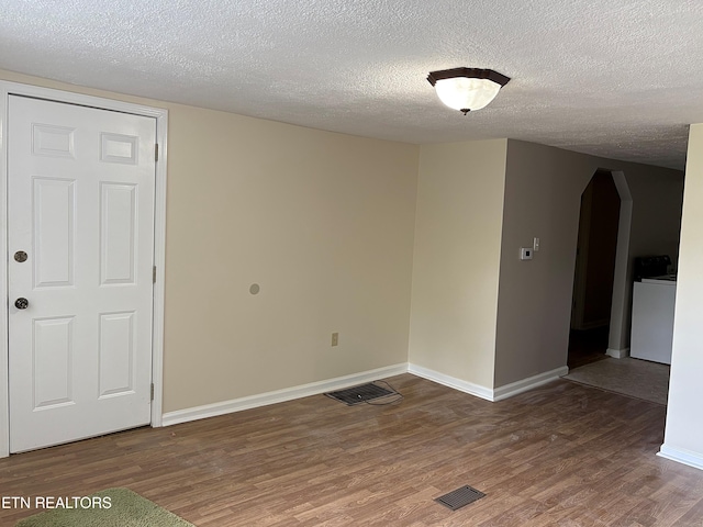 278 Buell Hill Rd, Pineville, KY 40977 - spare room with arched walkways, wood finished floors, a textured ceiling, and washer / clothes dryer