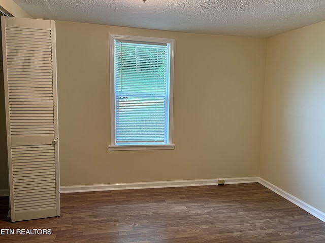 278 Buell Hill Rd, Pineville, KY 40977 - unfurnished bedroom featuring dark wood-type flooring, a closet, and a textured ceiling
