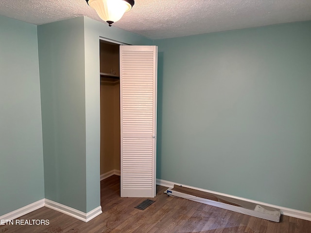 278 Buell Hill Rd, Pineville, KY 40977 - unfurnished bedroom with a closet, wood finished floors, and a textured ceiling