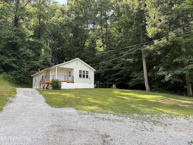 278 Buell Hill Rd, Pineville, KY 40977 - view of front facade with a front yard, gravel driveway, a porch, and a forest view