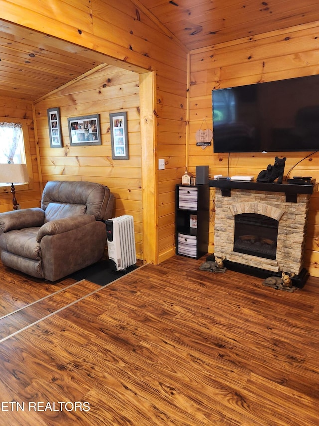151 Stonewall Way, Cosby, TN 37722 - living area featuring lofted ceiling, wood walls, wood finished floors, wooden ceiling, and a stone fireplace