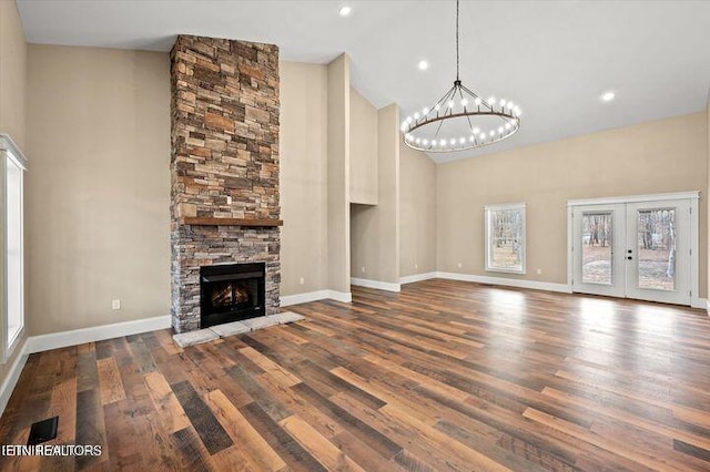 455 Sunset Harbor Dr, Dandridge, TN 37725 - unfurnished living room with high vaulted ceiling, a chandelier, wood finished floors, a stone fireplace, and french doors