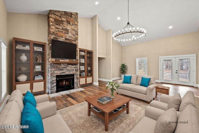 455 Sunset Harbor Dr, Dandridge, TN 37725 - living area with high vaulted ceiling, a chandelier, wood finished floors, a stone fireplace, and french doors