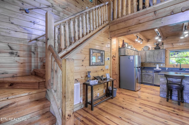 3012 Oak Tree Way, Pigeon Forge, TN 37863 - kitchen featuring stainless steel appliances, wood walls, a wooden ceiling with exposed beams, light wood-style floors, and track lighting