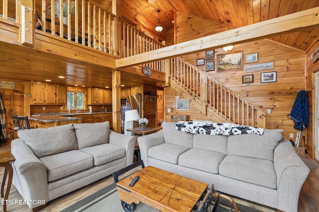 1818 Saddle Way, Sevierville, TN 37876 - living room featuring wood walls, wood ceiling, stairs, wood finished floors, and high vaulted ceiling