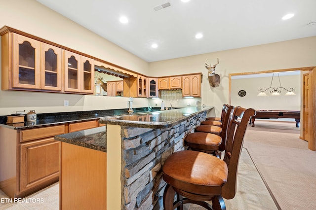 836 Sandra Way, Kodak, TN 37764 - kitchen with a breakfast bar area, dark stone countertops, light carpet, glass insert cabinets, and recessed lighting