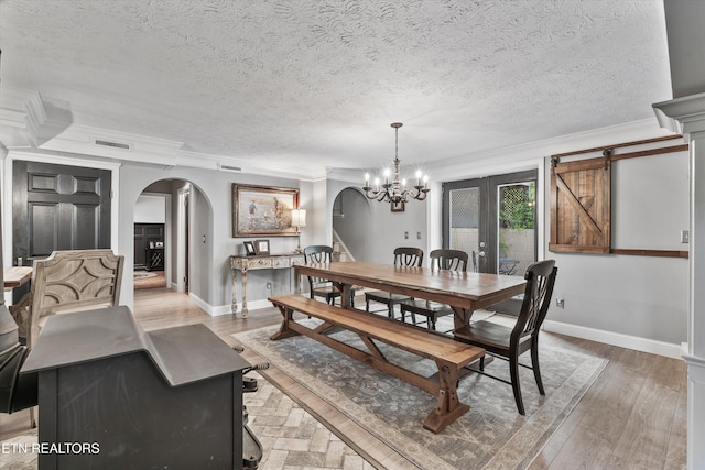976 Lone Rd, Pioneer, TN 37847 - dining area featuring arched walkways, ornamental molding, a textured ceiling, a chandelier, and light wood-style flooring