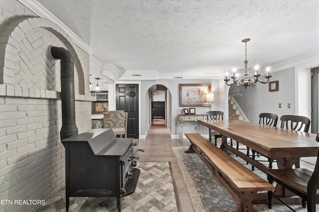 976 Lone Rd, Pioneer, TN 37847 - dining space featuring arched walkways, a chandelier, a textured ceiling, crown molding, and wood finished floors