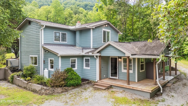 976 Lone Rd, Pioneer, TN 37847 - view of front facade featuring a wooded view, covered porch, a chimney, and a metal roof