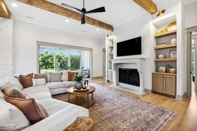 1014 High Springs Rd, Knoxville, TN 37932 - living room with a ceiling fan, beamed ceiling, light wood-style floors, a fireplace with flush hearth, and built in shelves