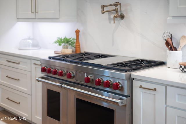 1014 High Springs Rd, Knoxville, TN 37932 - kitchen with range with two ovens, light countertops, white cabinetry, and backsplash