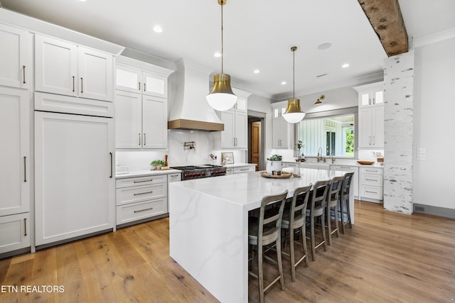 1014 High Springs Rd, Knoxville, TN 37932 - kitchen with custom exhaust hood, glass insert cabinets, white cabinetry, light wood finished floors, and ornamental molding