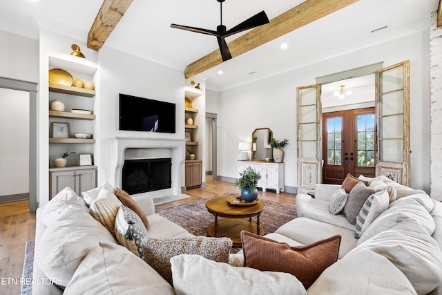 1014 High Springs Rd, Knoxville, TN 37932 - living room featuring light wood-style flooring, beamed ceiling, ceiling fan, french doors, and a fireplace with flush hearth