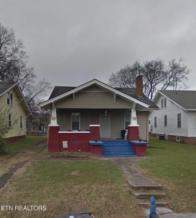 2919 Martin Luther King Jr Ave, Knoxville, TN 37914 - bungalow-style house featuring covered porch, a front lawn, a chimney, and brick siding