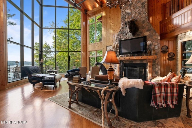 311 Deerwood Ln, Lafollette, TN 37766 - living room featuring high vaulted ceiling, wooden walls, a fireplace, and wood finished floors