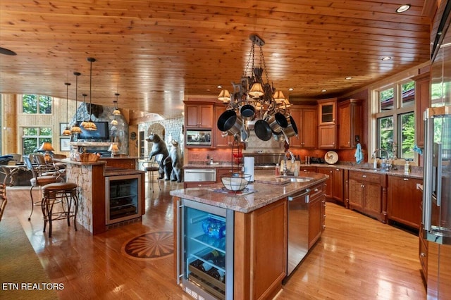 311 Deerwood Ln, Lafollette, TN 37766 - kitchen with wine cooler, brown cabinetry, a kitchen island with sink, wooden ceiling, and light wood-type flooring