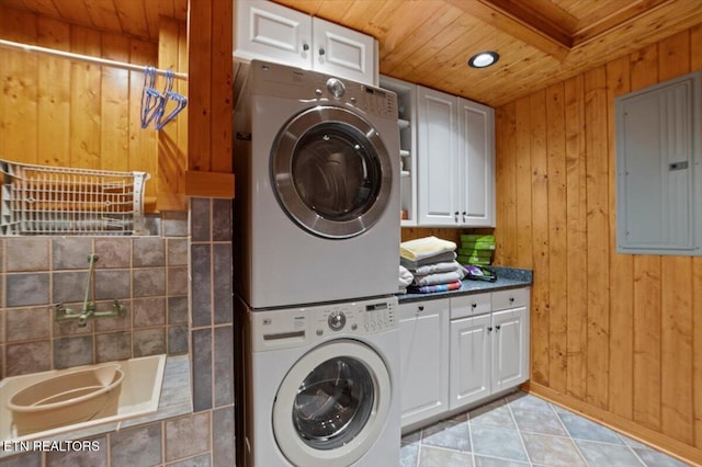 311 Deerwood Ln, Lafollette, TN 37766 - laundry area with electric panel, estacked washer and dryer, wooden ceiling, wooden walls, and cabinet space