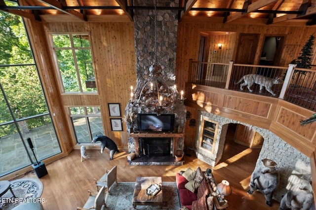 311 Deerwood Ln, Lafollette, TN 37766 - living room with beam ceiling, wooden walls, a fireplace, wood finished floors, and arched walkways