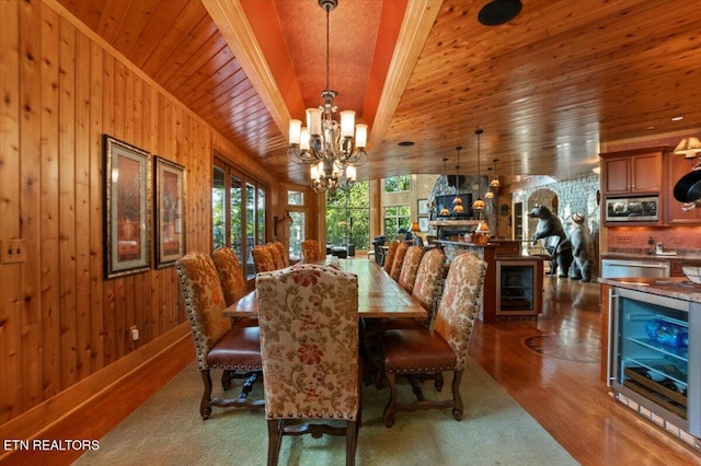 311 Deerwood Ln, Lafollette, TN 37766 - dining space with beverage cooler, a chandelier, a wood ceiling with exposed beams, wooden walls, and wood finished floors