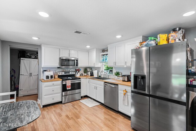 121 N Niota Rd, Englewood, TN 37329 - kitchen featuring appliances with stainless steel finishes, white cabinetry, decorative backsplash, butcher block counters, and recessed lighting