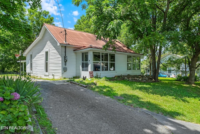 121 N Niota Rd, Englewood, TN 37329 - bungalow-style house with a front yard, a metal roof, a sunroom, and asphalt driveway