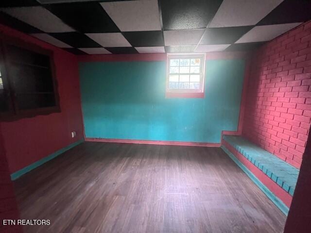 114 Red Cedar Rd, Lafollette, TN 37766 - spare room featuring wood finished floors, a drop ceiling, and brick wall