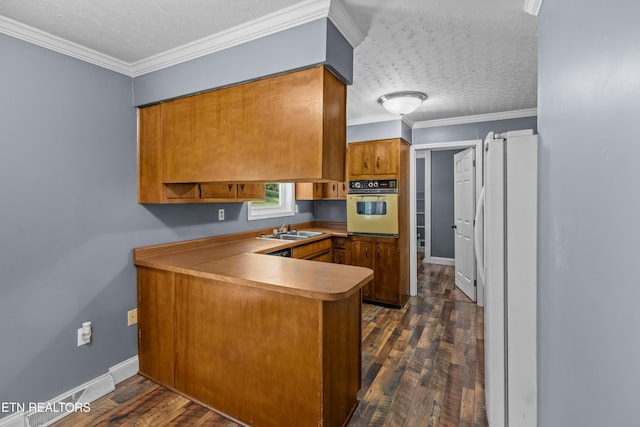 221 Greer Ln, Tazewell, TN 37879 - kitchen with white appliances, brown cabinets, a peninsula, a textured ceiling, and dark wood-type flooring