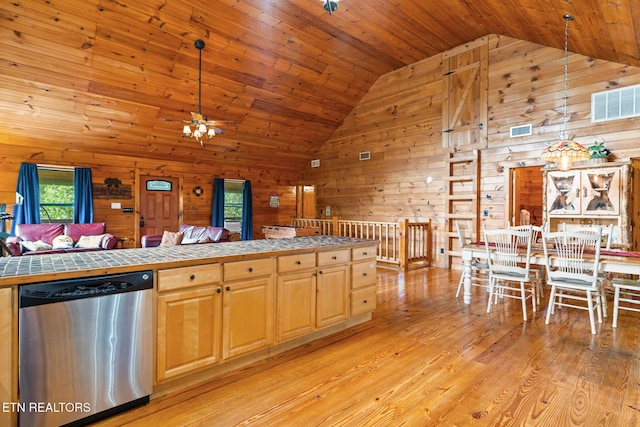 1130 Sharp Rd, Sevierville, TN 37876 - kitchen with stainless steel dishwasher, tile counters, wooden walls, high vaulted ceiling, and light wood-style flooring