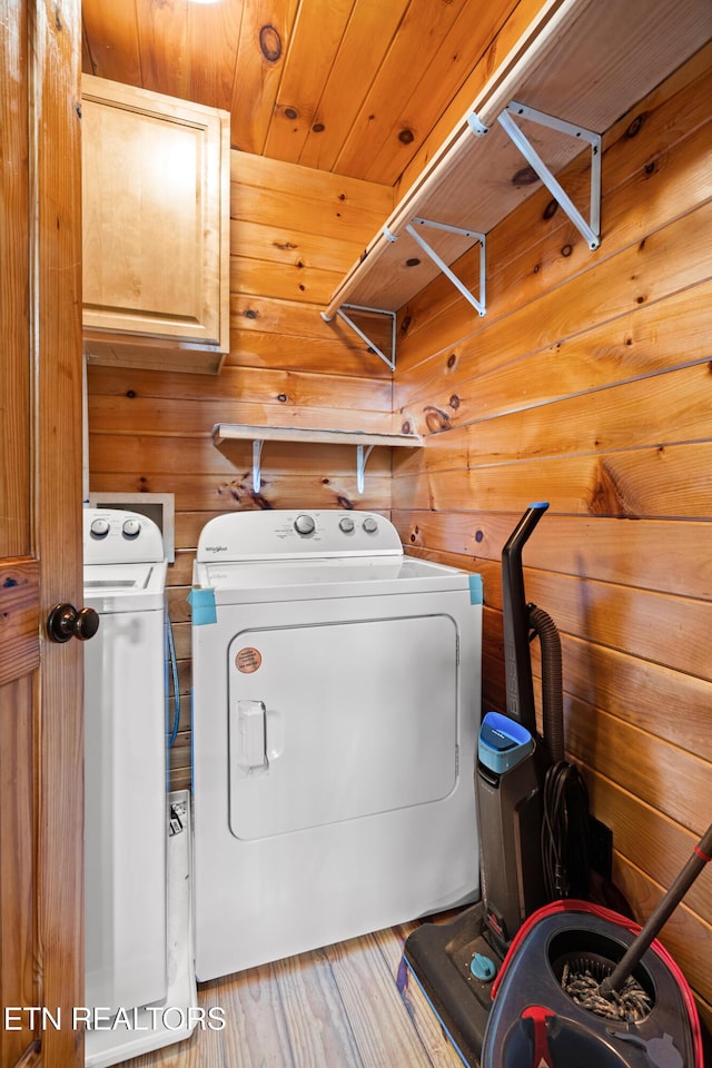 1130 Sharp Rd, Sevierville, TN 37876 - washroom with washing machine and dryer, wood walls, cabinet space, and wood finished floors