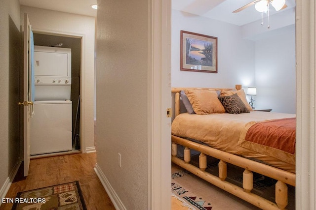 537 Johnson Ln Unit 1 & 2, Gatlinburg, TN 37738 - bedroom featuring stacked washer / dryer, wood finished floors, and ceiling fan